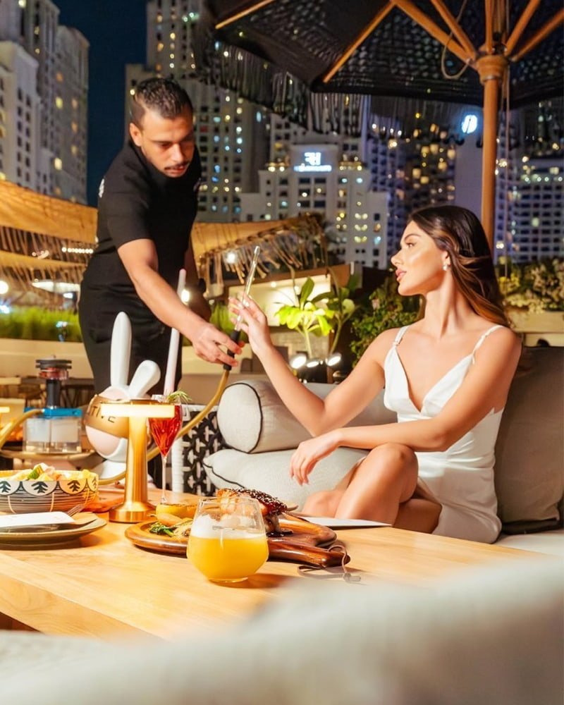 waiter presenting shisha to a lady